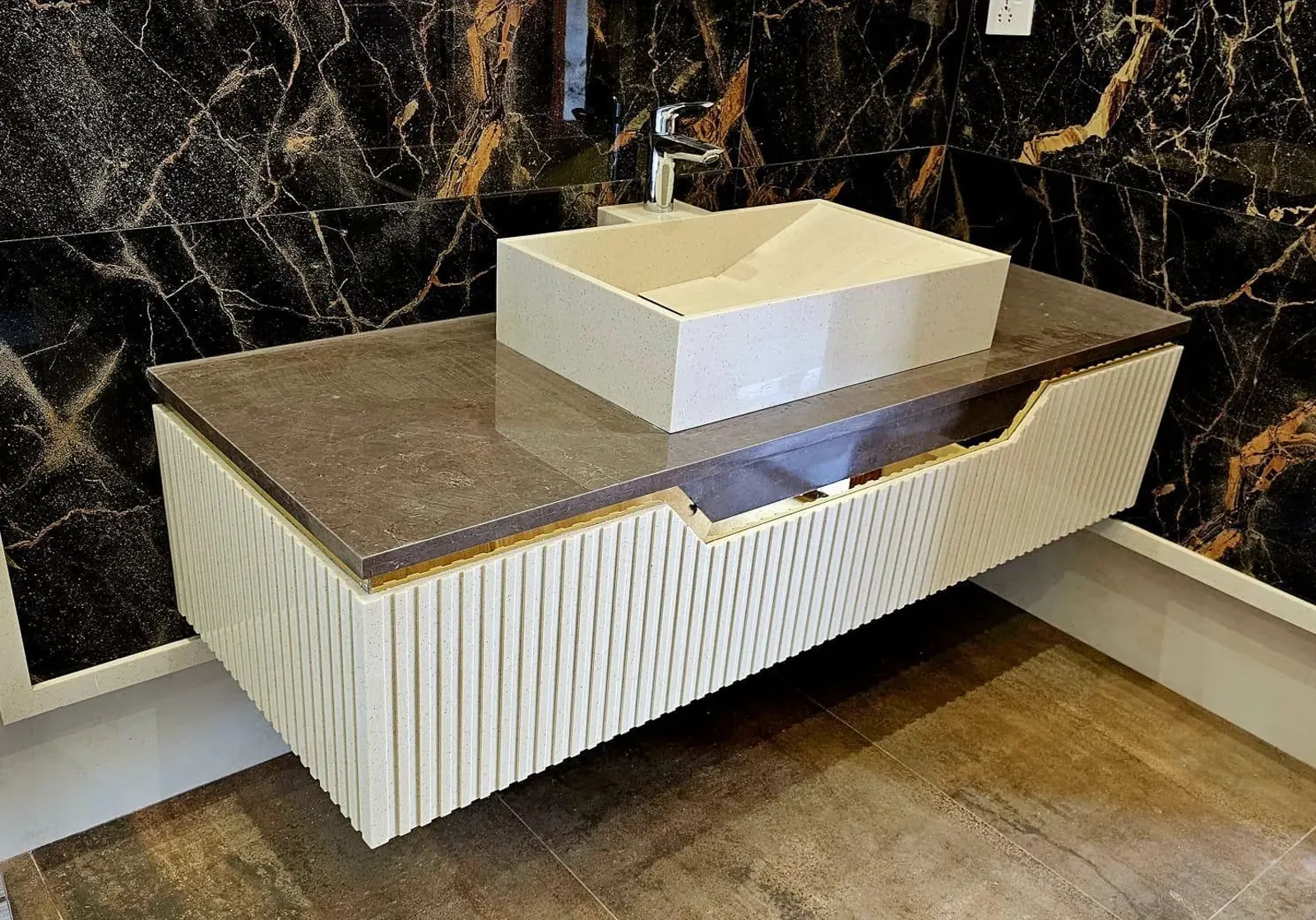 Close-up of a fluted Corian floating vanity with seamless joints and a stone top, fabricated in Lahore by Style Concept.