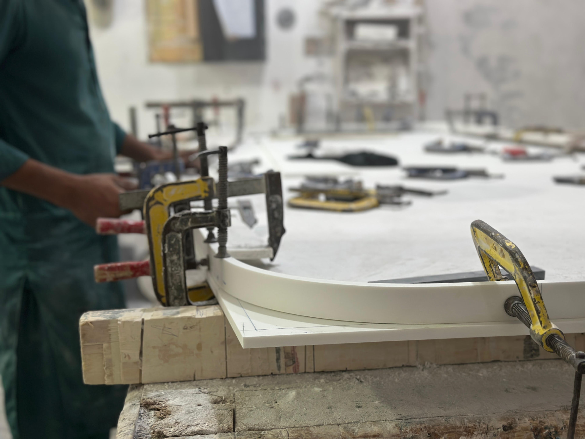 Thermoformed Corian edge held in clamps while the adhesive cures