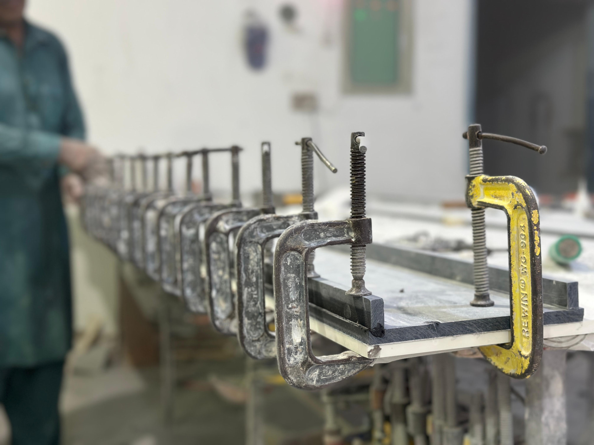 Row of clamps holding a laminated solid-surface seam