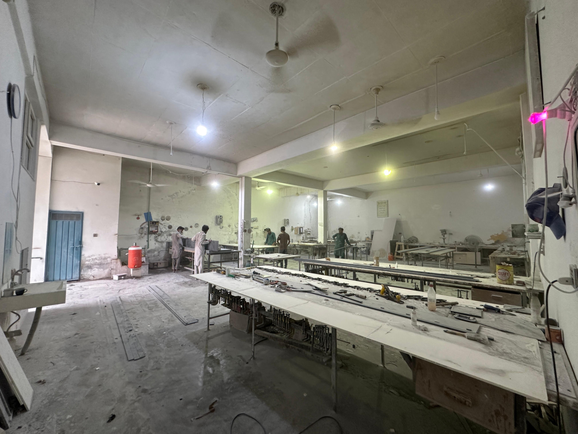 Wide view of the Lahore workshop with fabrication tables and tooling